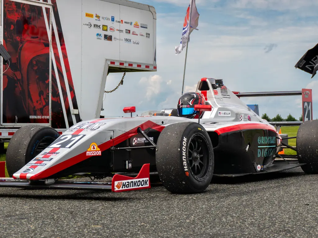 Aj abdullah in the number 21 berg racing ligier junior formula car staged in the paddock at virginia international raceway.