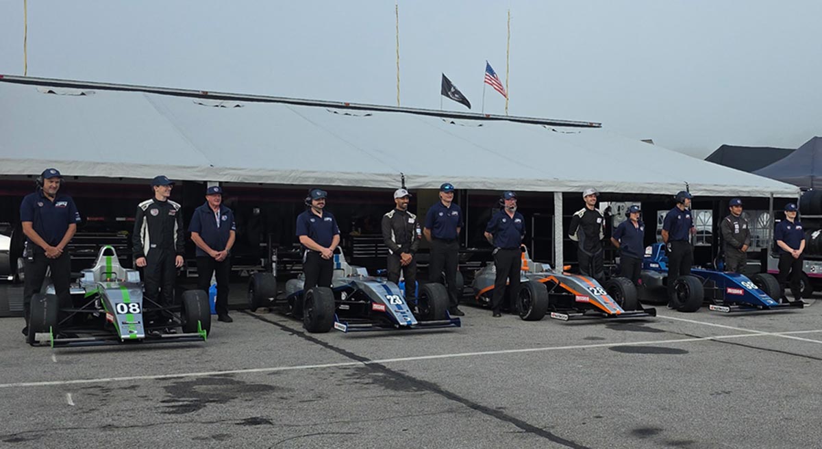Berg racing team and crew with three formula cars lined up at virginia international raceway