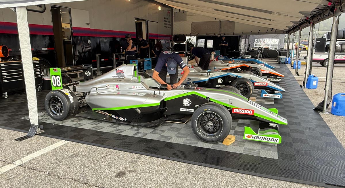 Berg racing crew working in garage on race cars and equipment
