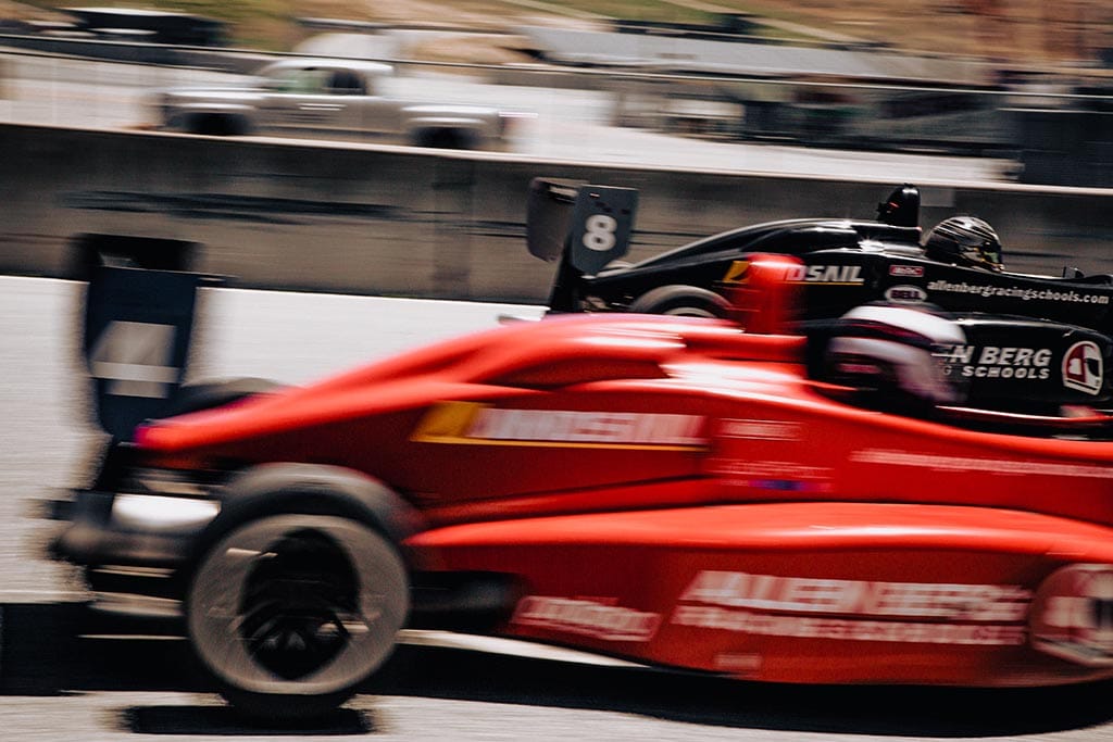 Red formula 1 car racing with black formula 1 car