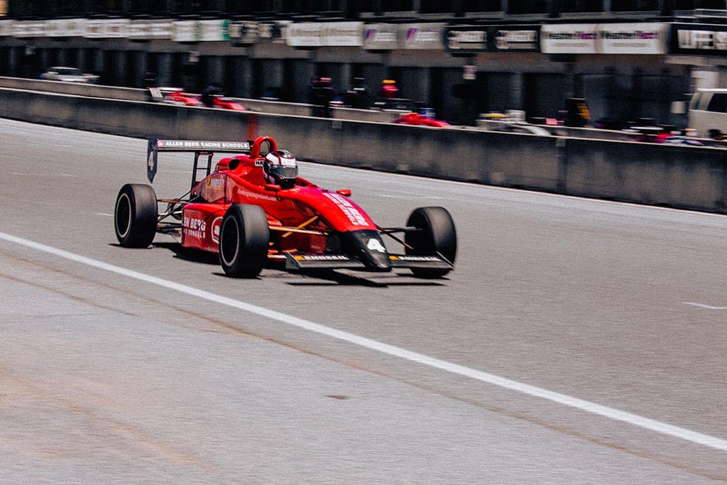 Red color formula 1 racing car on track